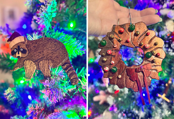 Wholesome Christmas ornaments on a tree: a raccoon with a Santa hat and a festive wreath with red and green decorations.