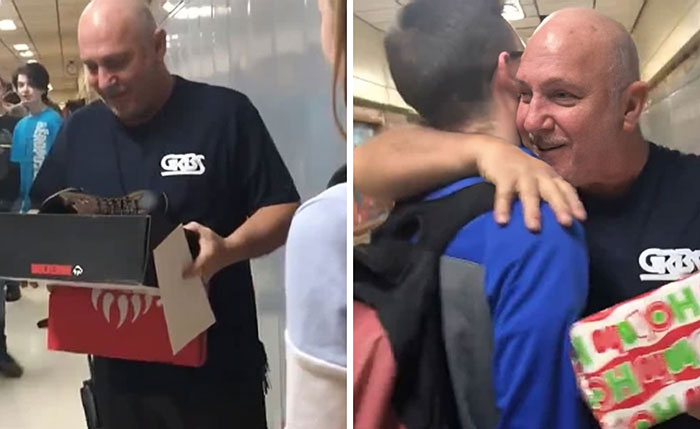 Man holding gifts and hugging a student in a school hallway, spreading wholesome Christmas cheer.