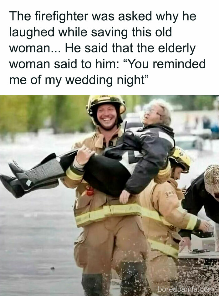 Firefighter carrying elderly woman, both smiling, showing wholesome kindness during rescue operation.