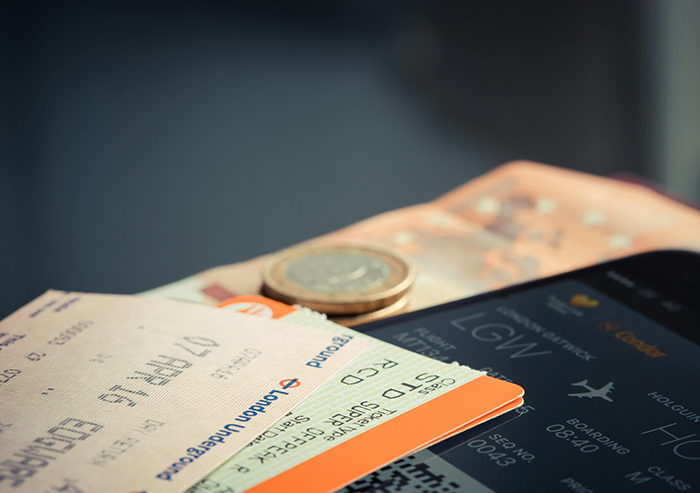 Airline tickets and currency on a table, symbolizing a planned Japan trip cancellation.