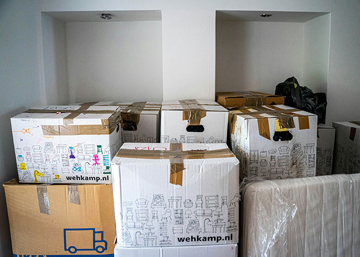 Moving boxes stacked in a room, symbolizing family boundary challenges.