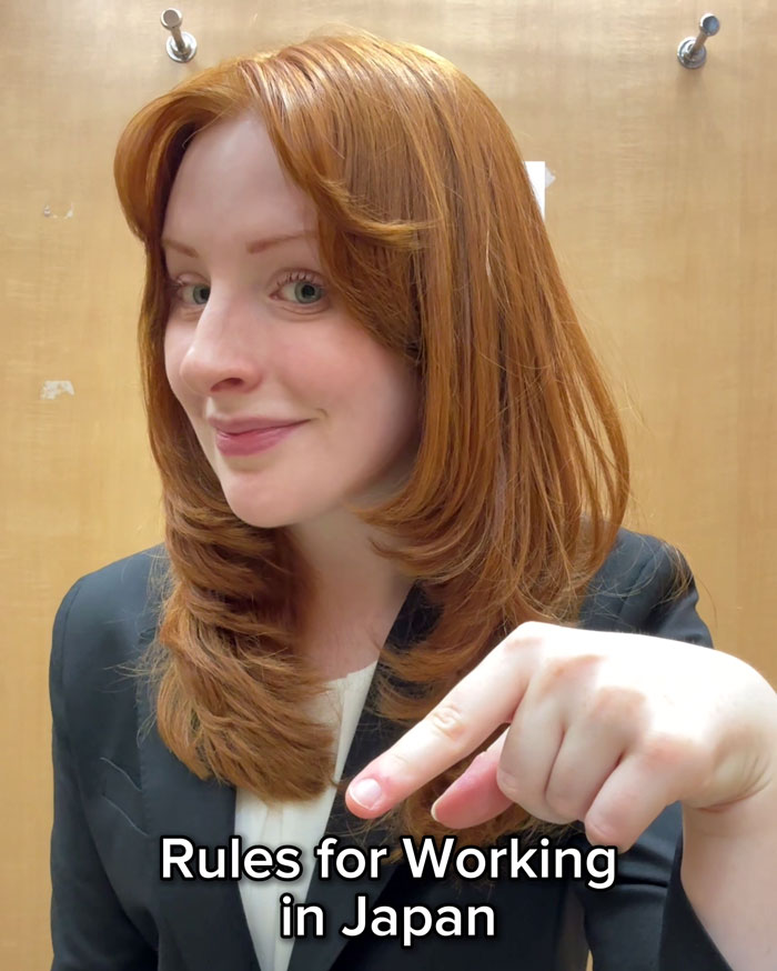 Woman highlighting work rules in Japan, smiling and pointing with a finger.