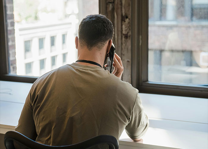 Man on phone looking out window during worst things happened Christmas conversation.