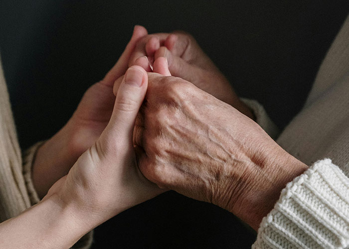 Two people holding hands, illustrating comfort during difficult Christmas moments.