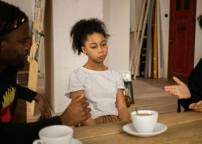 Three people having a serious discussion over coffee, capturing one of the worst things happened during Christmas.