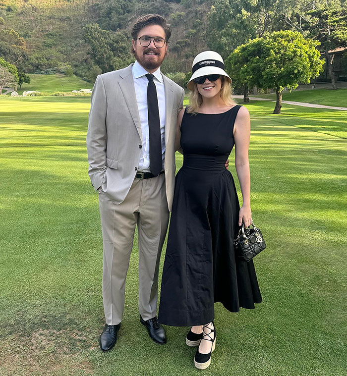 Couple in elegant attire at outdoor event, linked to viral $59M wedding announcement and legal issues.