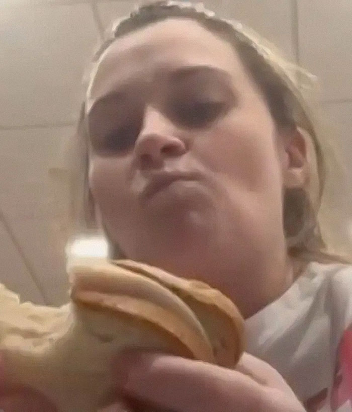 Woman eating a sandwich, looking at the camera; related to NICU monitor incident.