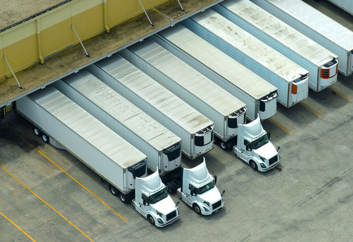 Overhead view of semi-trucks at a loading dock, representing a booming business.