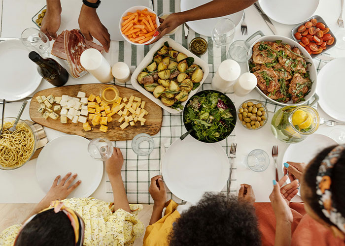 Dinner party with diverse dishes, showcasing a Canadian woman's culinary spread on a beautifully set table.