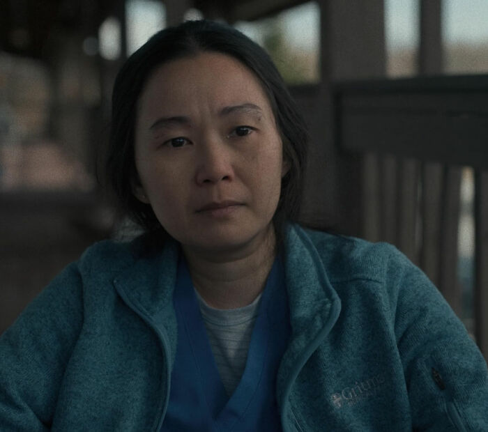 Actor in a teal jacket sitting indoors, symbolizing pigeonholed talent in film roles.