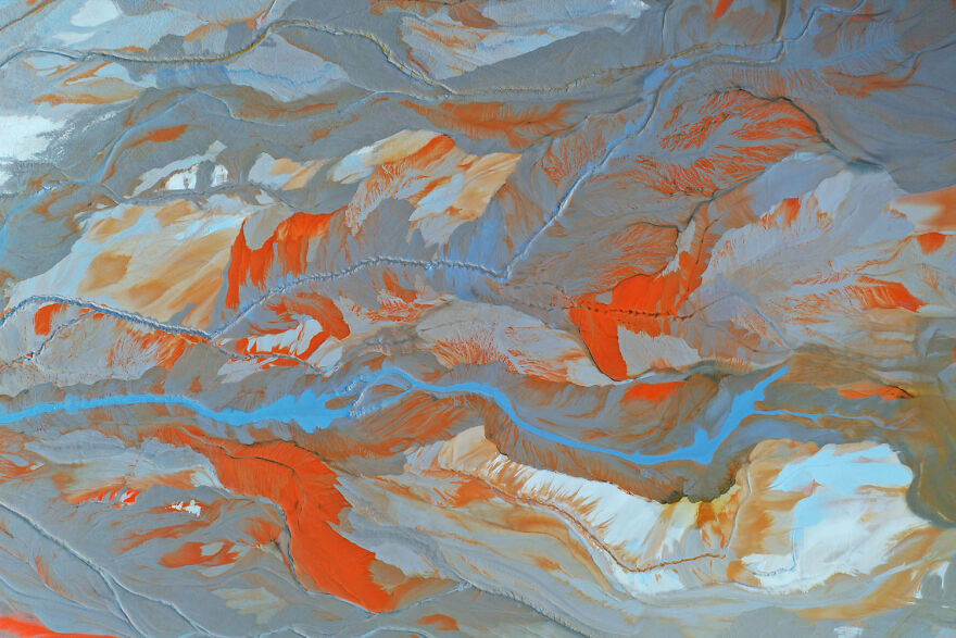 Aerial view of a colorful landscape with rivers and mountains, part of wildlife photos in a 2024 photography contest.