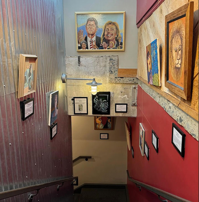 Stairway gallery with a painting depicting a couple, inspired by a viral painting of a man's wife.