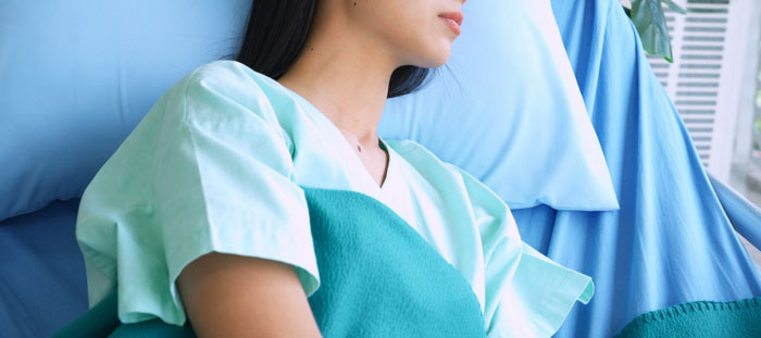 A woman in a hospital bed, representing family secrets.