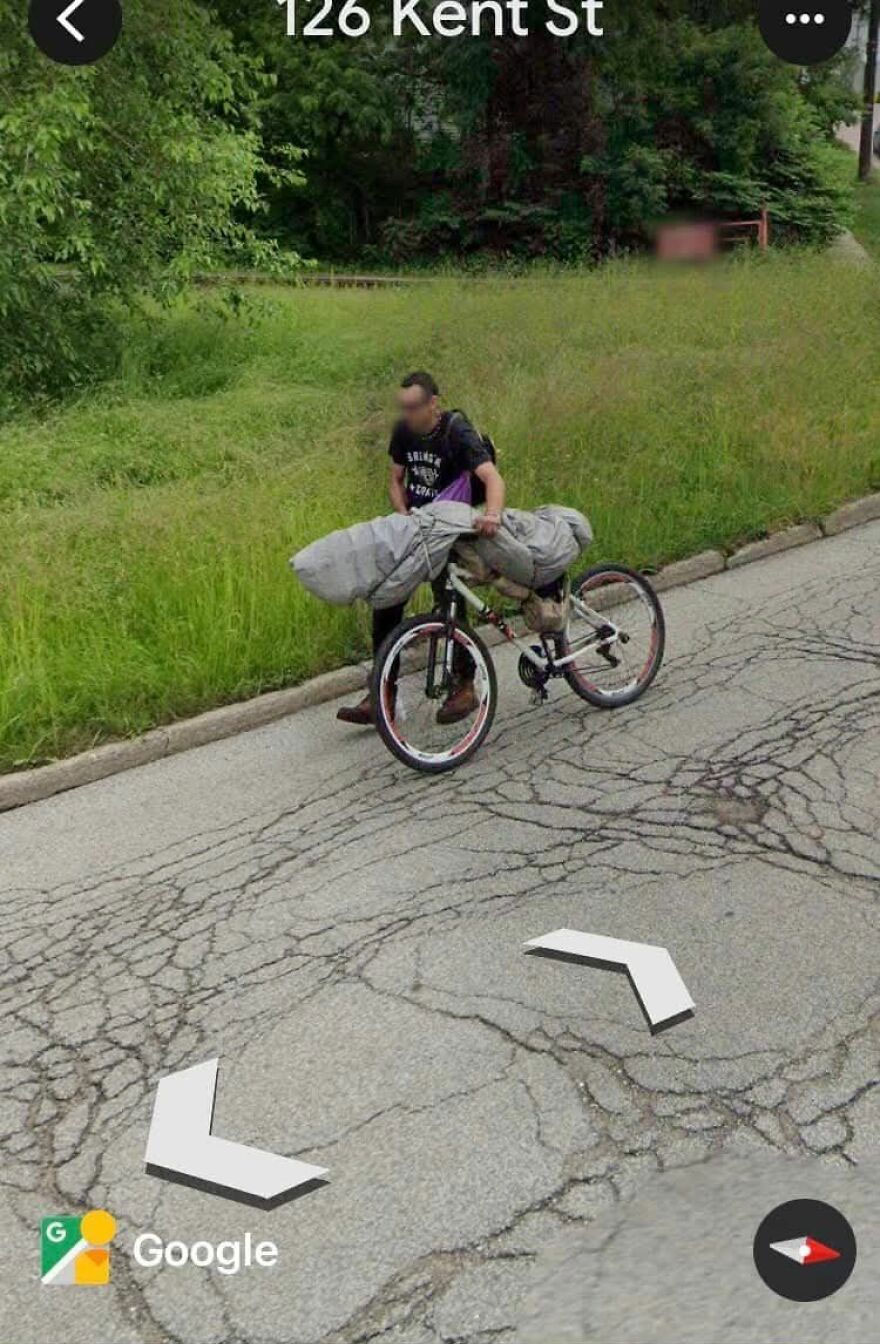 Person with a bicycle carrying a large, wrapped item on Google Earth at 126 Kent St.