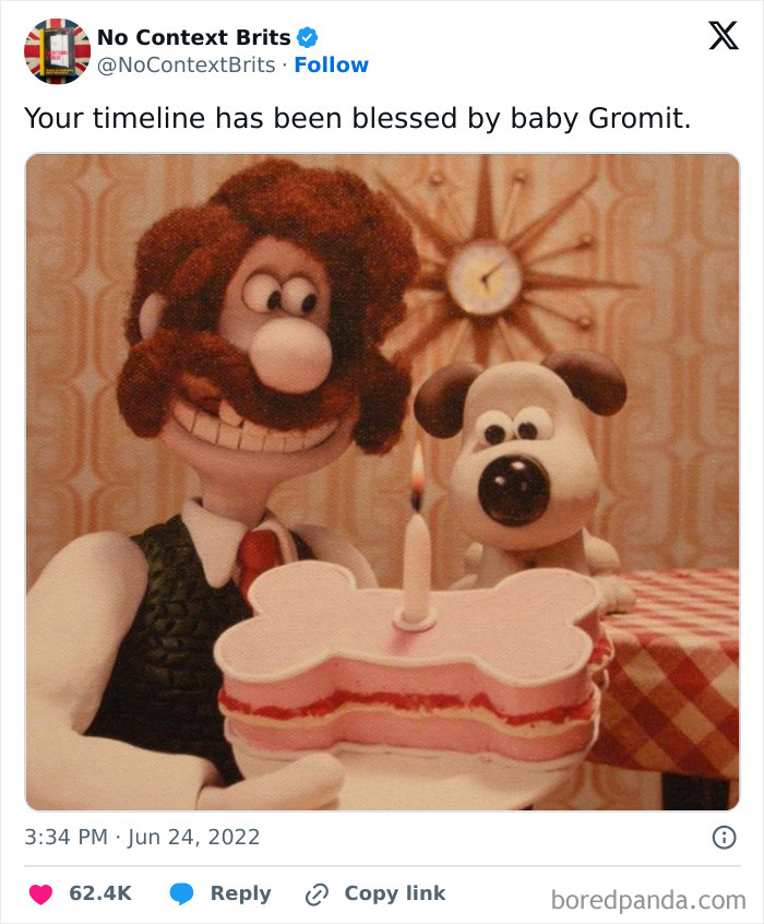 British clay figures holding a bone-shaped cake with a candle, creating a whimsical scene.