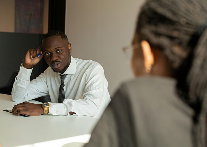 Two individuals in a job interview setting, conveying an awkward and tense atmosphere.