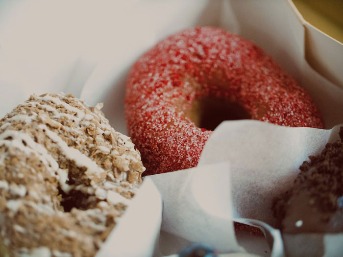 Assorted donuts in a box, featuring a red sugar-coated donut, showcasing quality hacks for delicious treats.