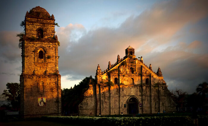 Historic church with an intricate facade bathed in golden sunlight, highlighting its architectural beauty.