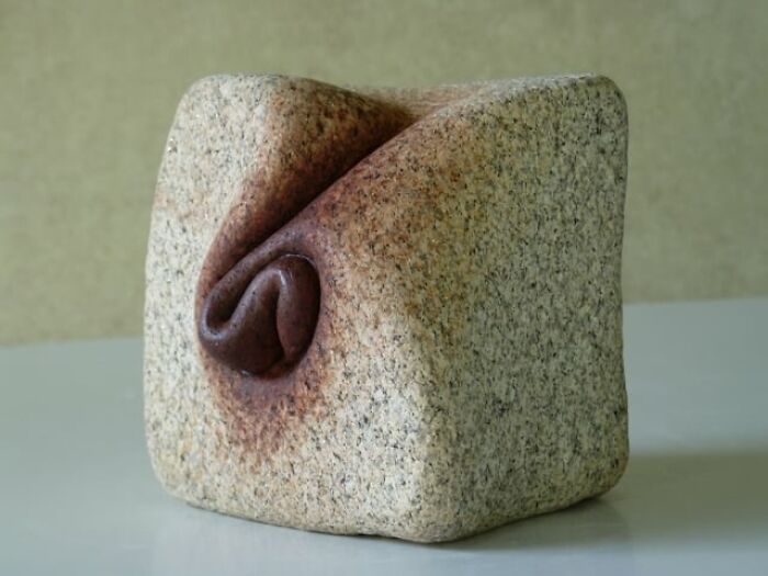 Intricate stone sculpture creating an illusion of soft, folded fabric.