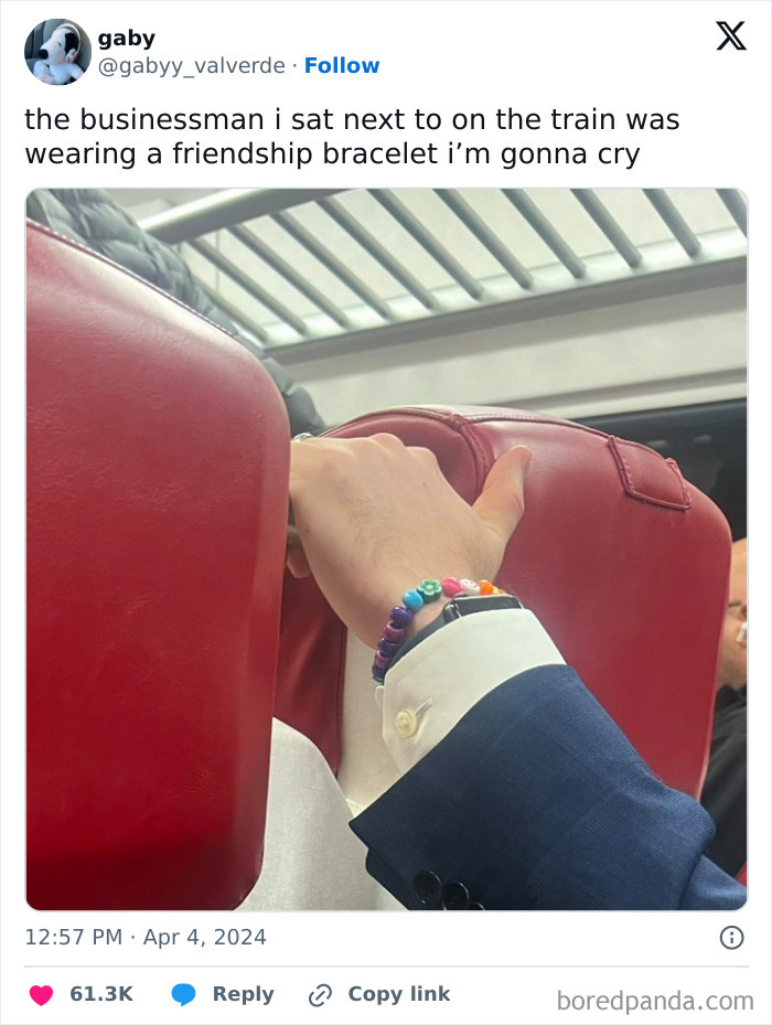 Businessman on train wearing a colorful friendship bracelet, creating a lighthearted moment among subway passengers.