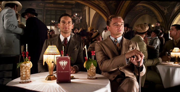 Two men in vintage suits sitting at a stylish bar, used in fascinating fan theories discussions.