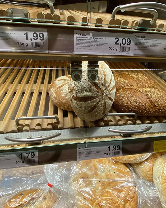 Bread display in a grocery store with price tags, featuring various loaves including Chia and Dinkelbrot.