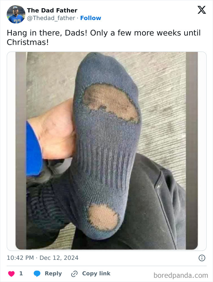 A dad holding up a sock with holes, capturing the daily struggles in a humorous way.