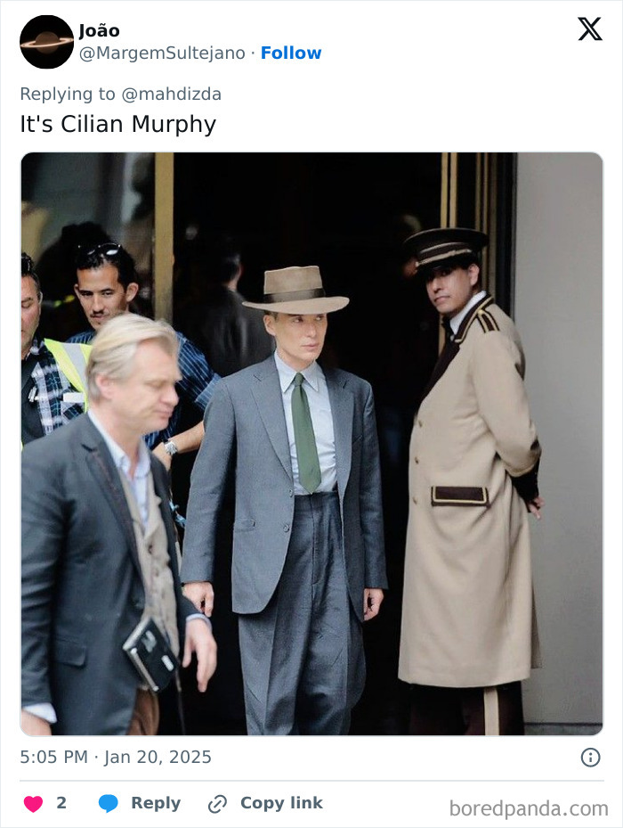 People standing around a man in a suit and hat, related to body double rumors.