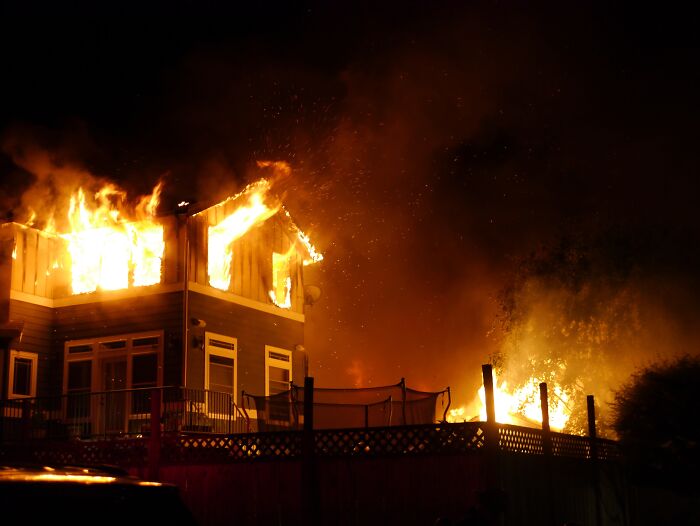 House engulfed in flames at night, illustrating dramatic twists in true crime cases.