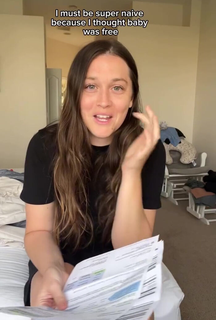 Woman surprised with a large hospital bill for her baby, holding documents in a confused expression.