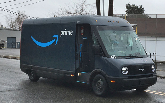 Amazon Prime delivery van parked on a street in rainy weather.