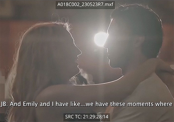 Two people in a close embrace, silhouetted against a bright light, with subtitles discussing intimate moments.