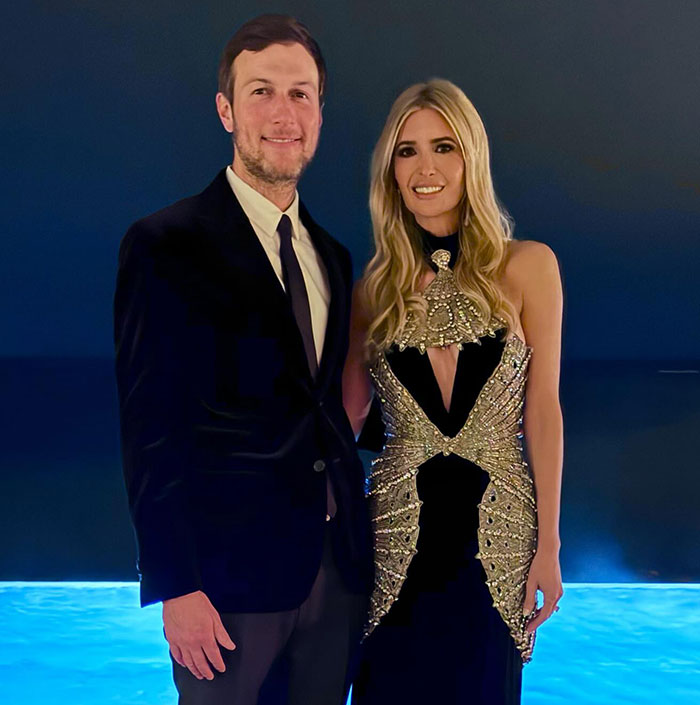 Elegant couple posing, with woman in embellished dress.