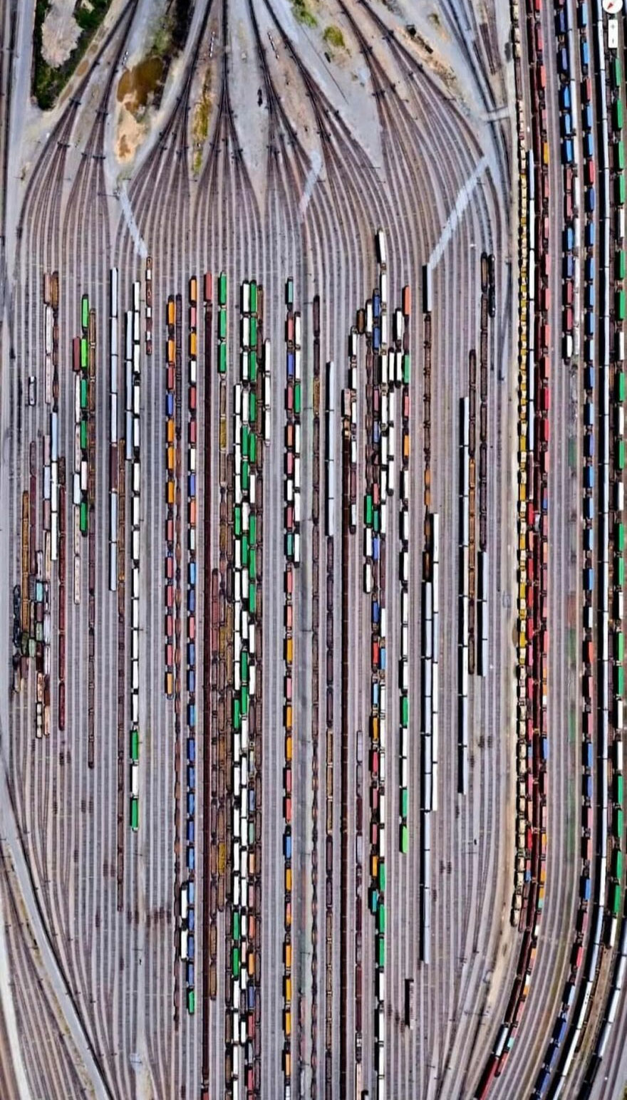 Aerial view of colorful train cars on tracks, a strange sight discovered on Google Earth.