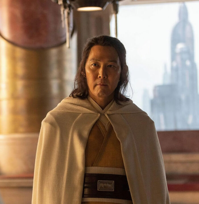 Actor in costume with long hair and a cloak, posing thoughtfully in a sci-fi setting, showcasing their talent despite pigeonholed roles.