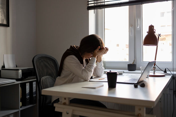 Person sitting at a desk looking stressed, highlighting realization of something messed up.