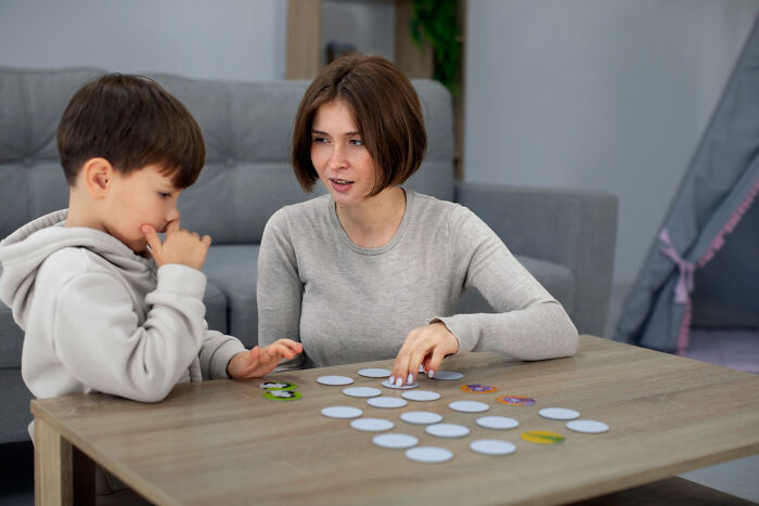 Woman and child engaging in a memory game, showcasing displays of genius.