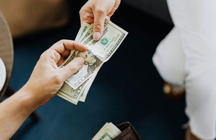 Exchange of cash between hands, depicting potential corruption by officers.