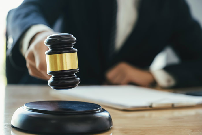 Judge using a gavel in a courtroom, symbolizing unresolved true crime cold cases.