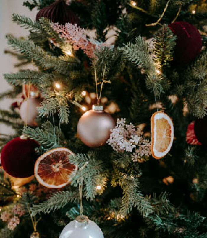 Family secret-themed holiday tree with dried orange slices and baubles.