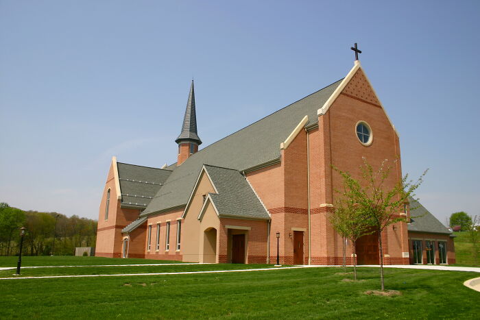 Beautiful church with a tall steeple and brick exterior set against a clear sky.