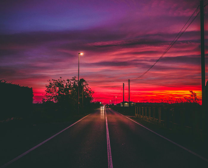 Dramatic sunset over an empty road, evoking feelings related to unsolved true crime cold cases.