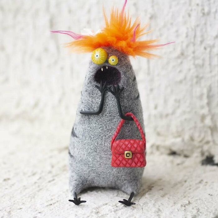 Strange art doll resembling a funny-looking animal, with orange hair and a red purse, by a Georgian artist.