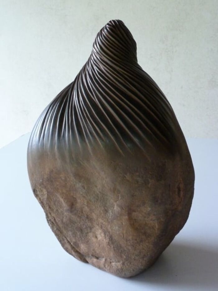 Stone sculpture with twisted top, showcasing intricate textures that defy physics.