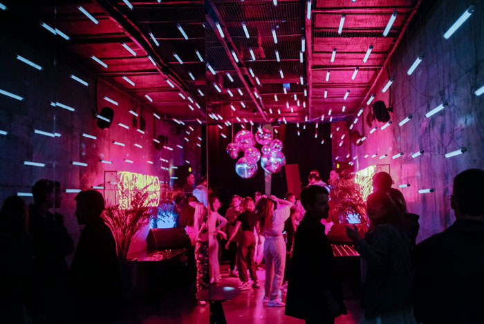 People dancing in a vibrant room with neon lights and disco balls, related to true crime cold cases.