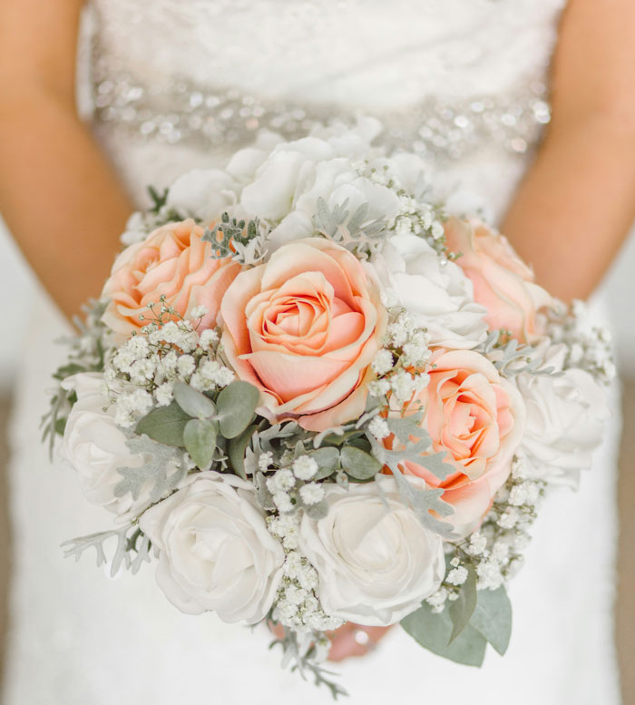 Bridal bouquet with peach and white roses, symbolizing untold family stories.