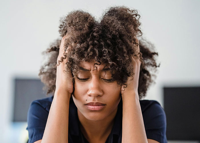 Woman looking upset, hands on face, reflecting emotions related to AI image comparison.