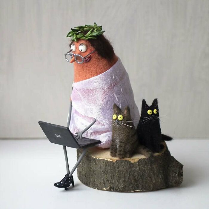 Strange art dolls: a whimsical animal figure with glasses and a laptop, accompanied by two quirky cats on a wooden base.