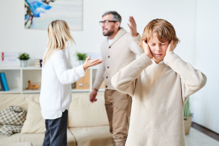 Child covering ears as parents argue, highlighting realization of family issues when older.