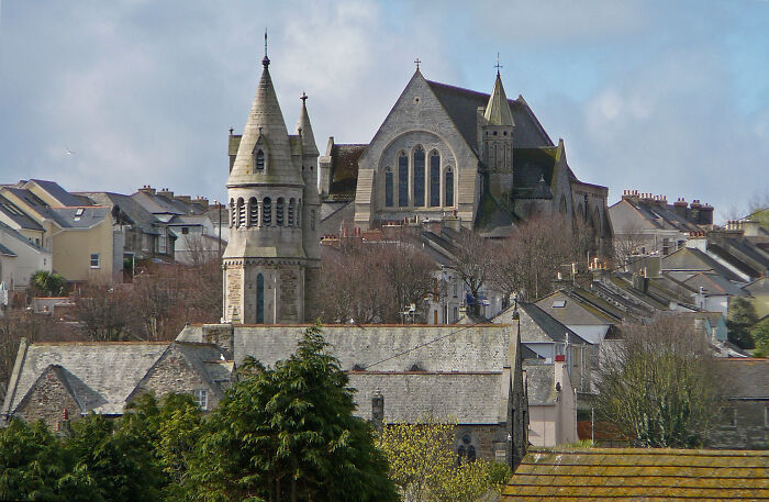 Historic church building with tall spires amid a residential area, showcasing fascinating architecture.